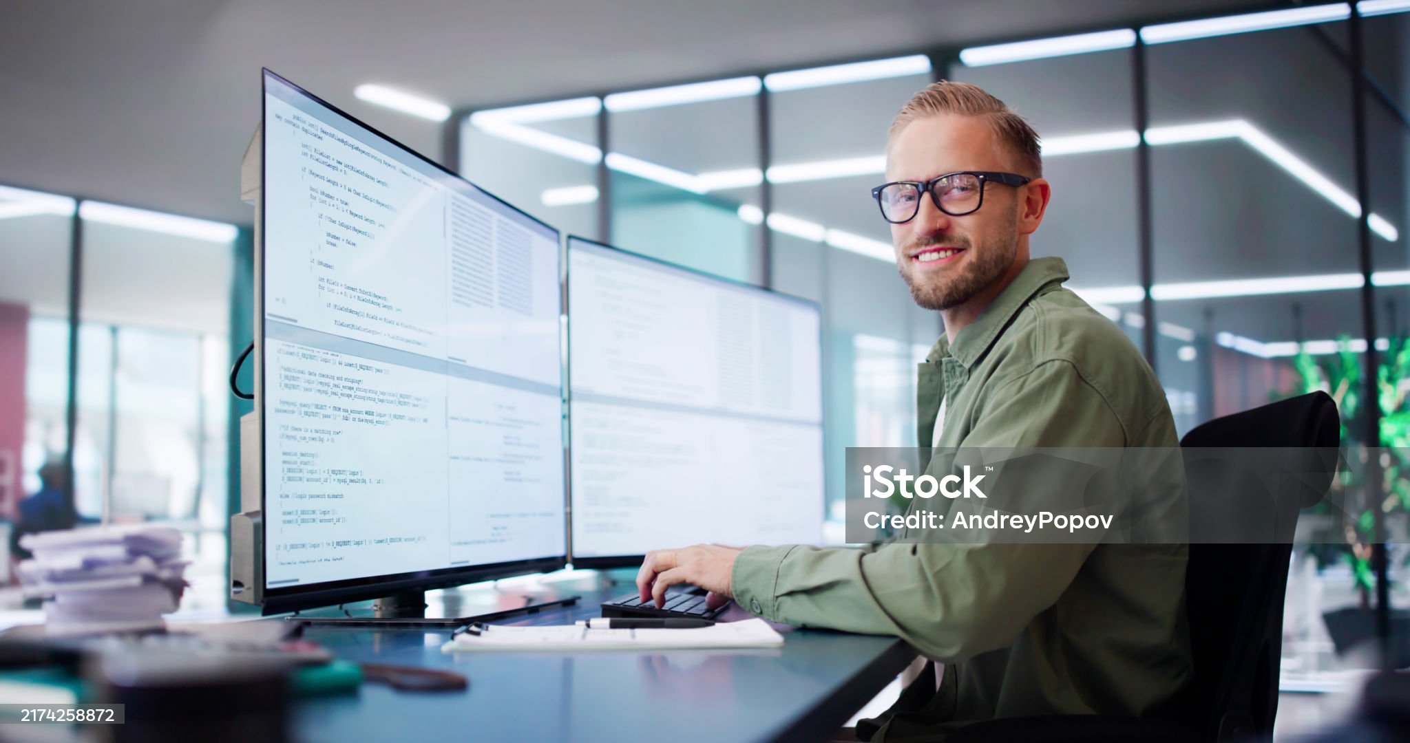Computer Programmer Writing Program Code On Computer In Office